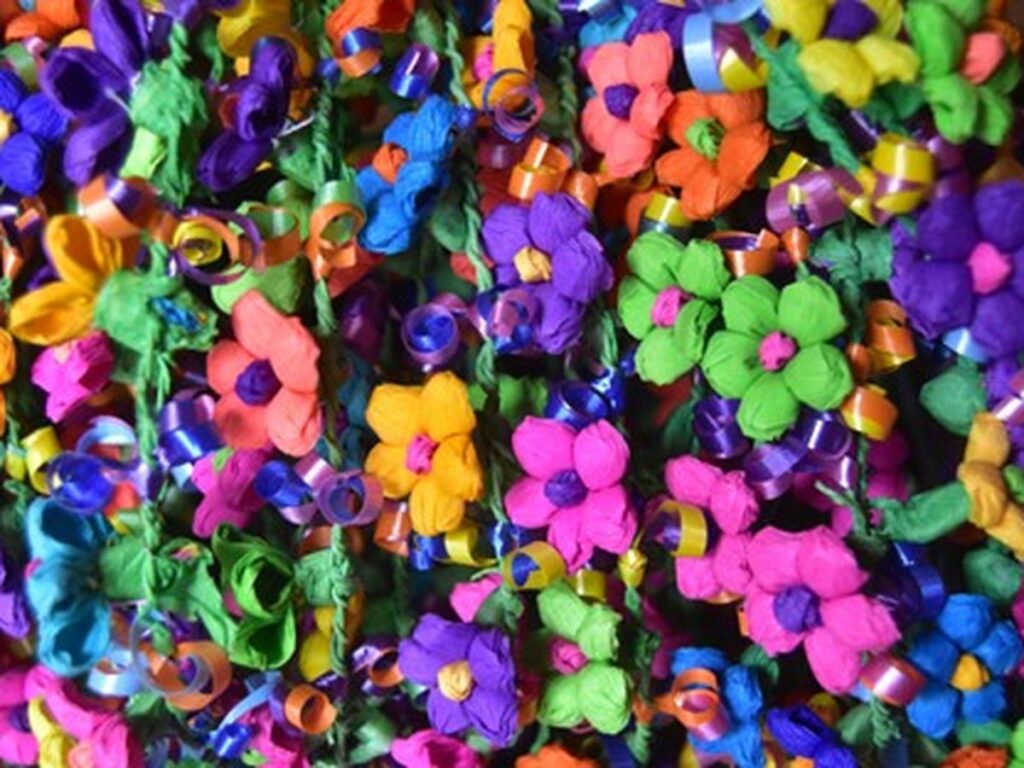 Vibrant handmade Fiesta flowers with curled ribbons in bright colors, representing San Antonio’s festive culture
