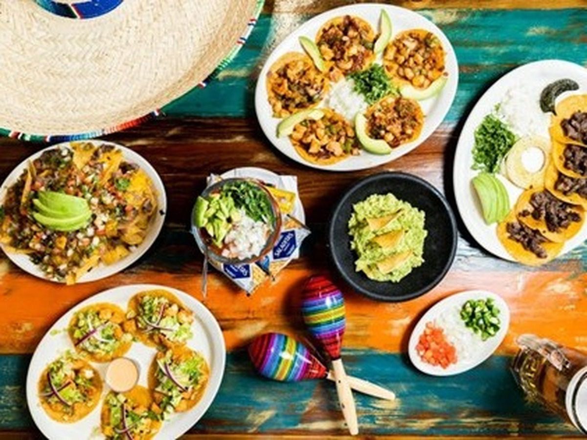 A colorful table filled with plates of Mexican food
