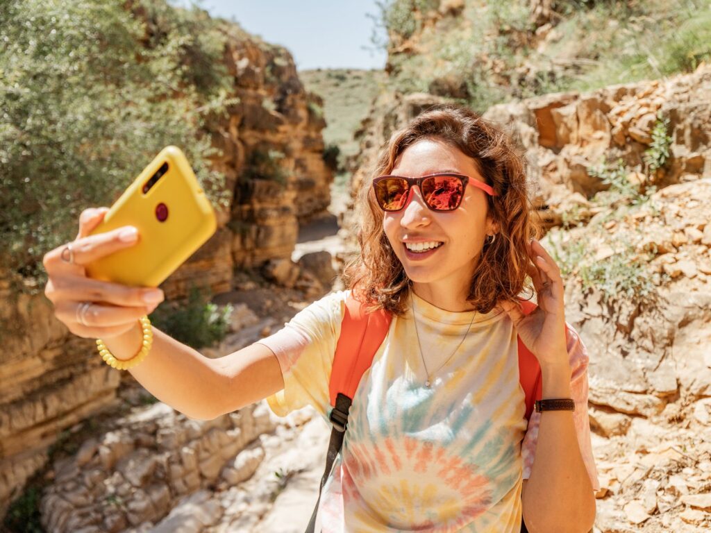 A woman takes selfies in a picturesque canyon in the desert