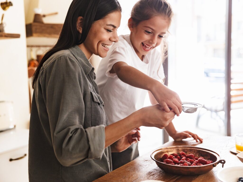 Woman and her little daughter cooking together at home