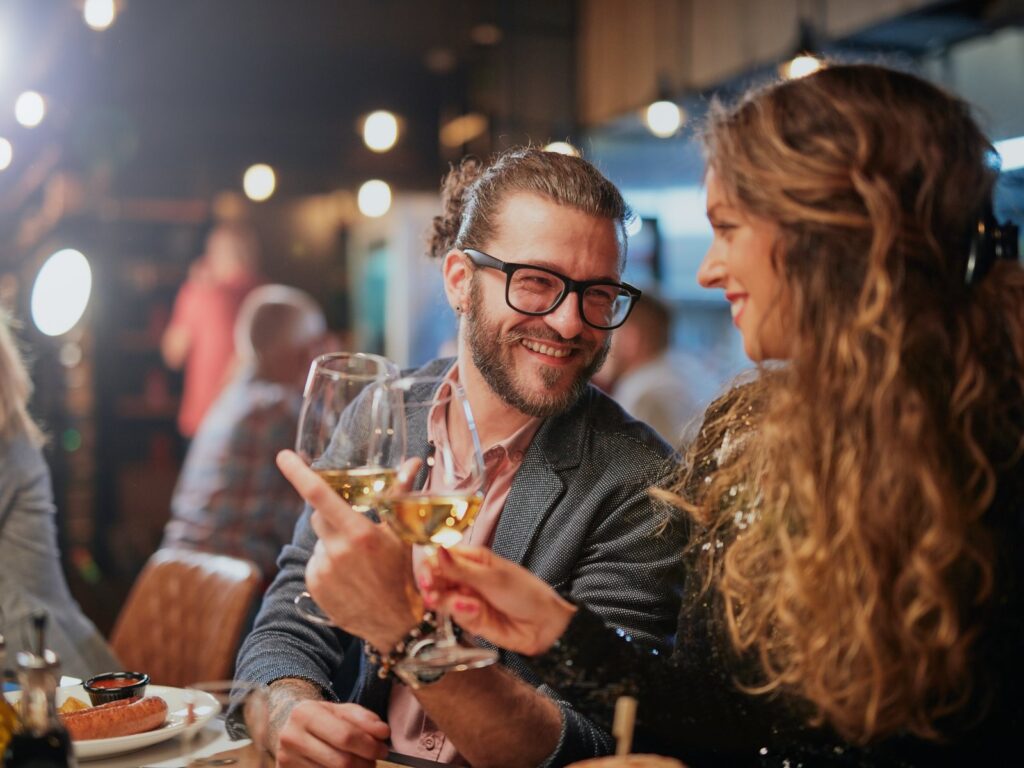 Cute couple sitting in a restaurant at night with wine.