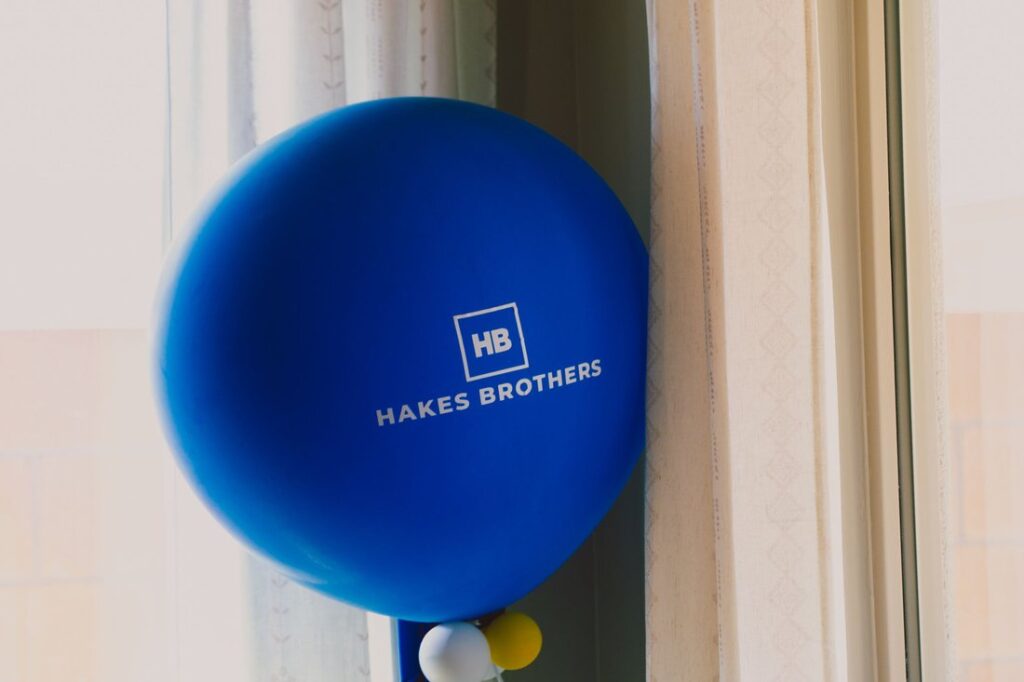 Celebratory balloons with the Hakes Brothers logo printed on them.