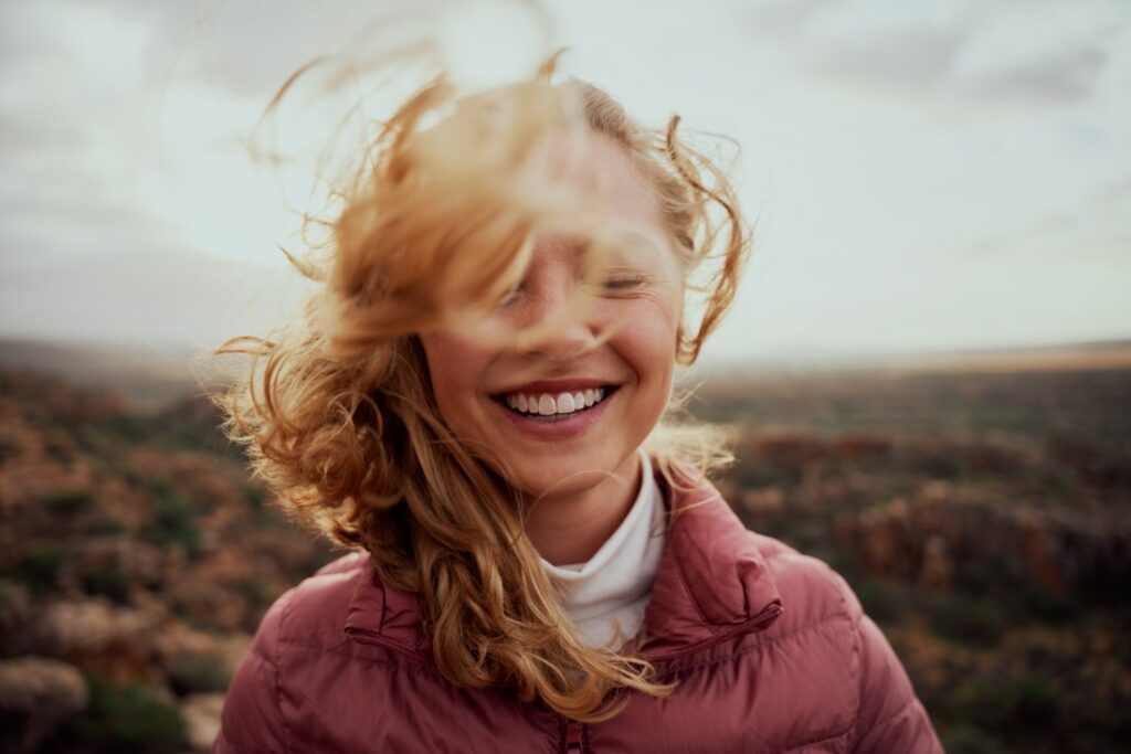 Woman smiling in the wind out in nature