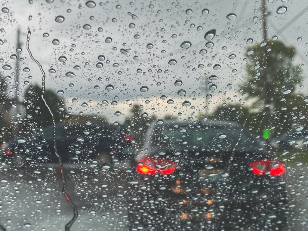 Car sitting in traffic on a rainy day.