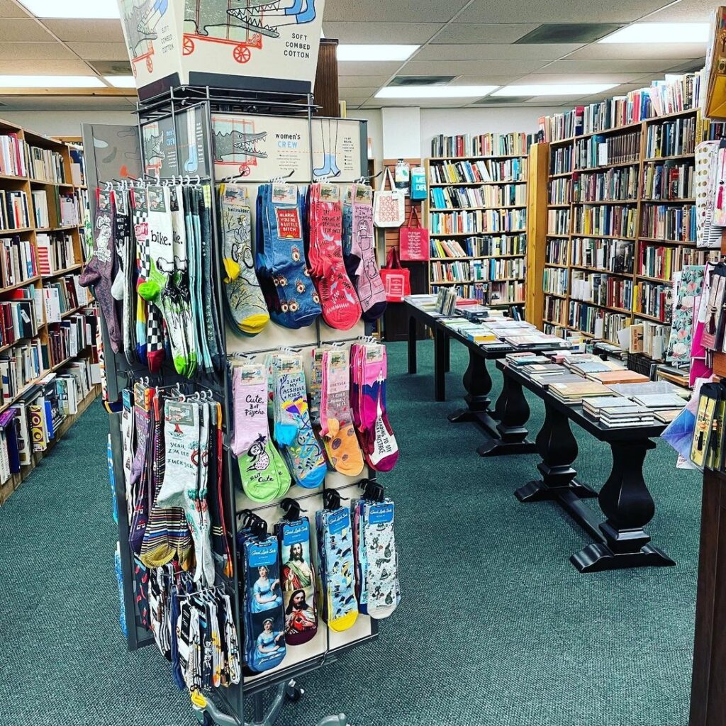 The interior of COAS Books in Las Cruces featuring rows and tables of books.