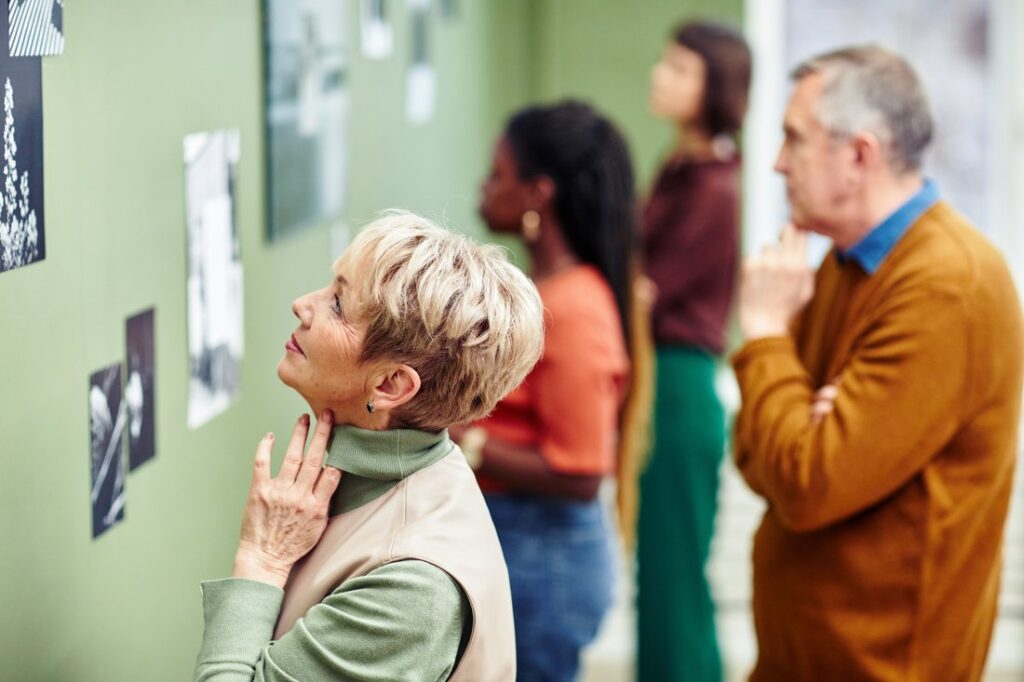 Senior and young people visiting black and white photography exhibition.