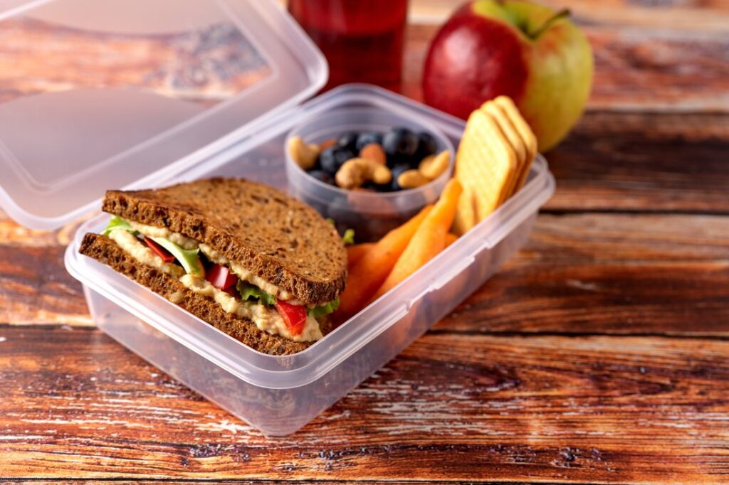 Close up of school lunch box with sandwich, nuts and berries