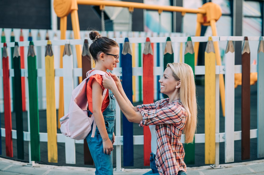 Mom saying goodbye to her daughter before going to school