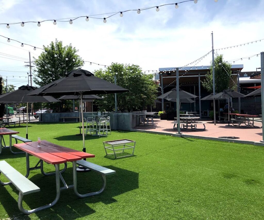 Outdoor dining picnic tables at Char Bar on a sunny day.