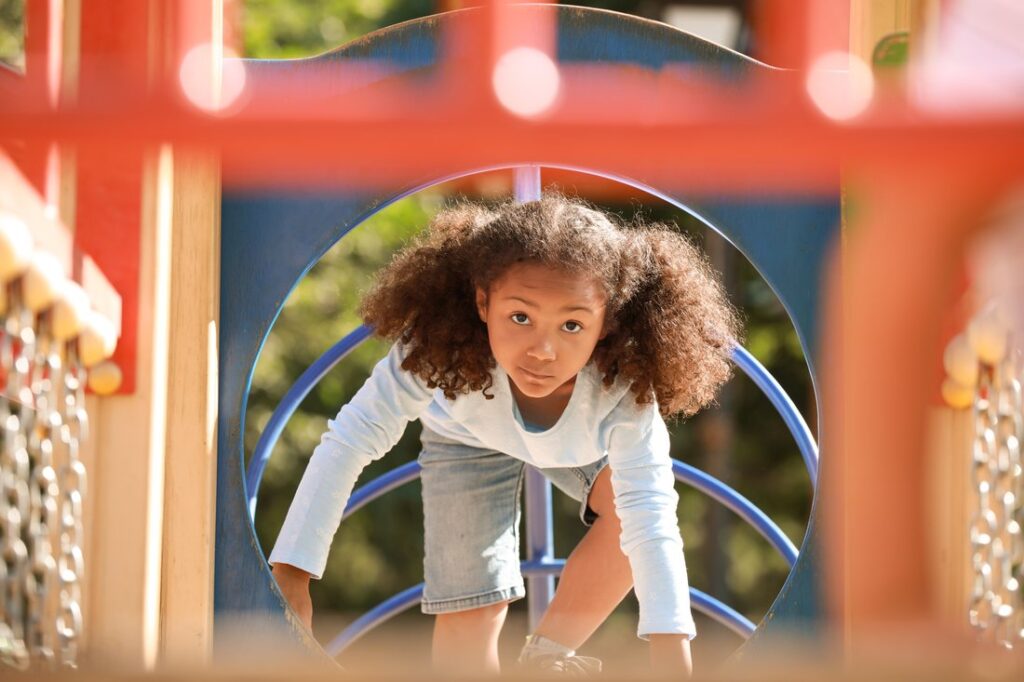Cute little girl having fun on playground outdoors.
